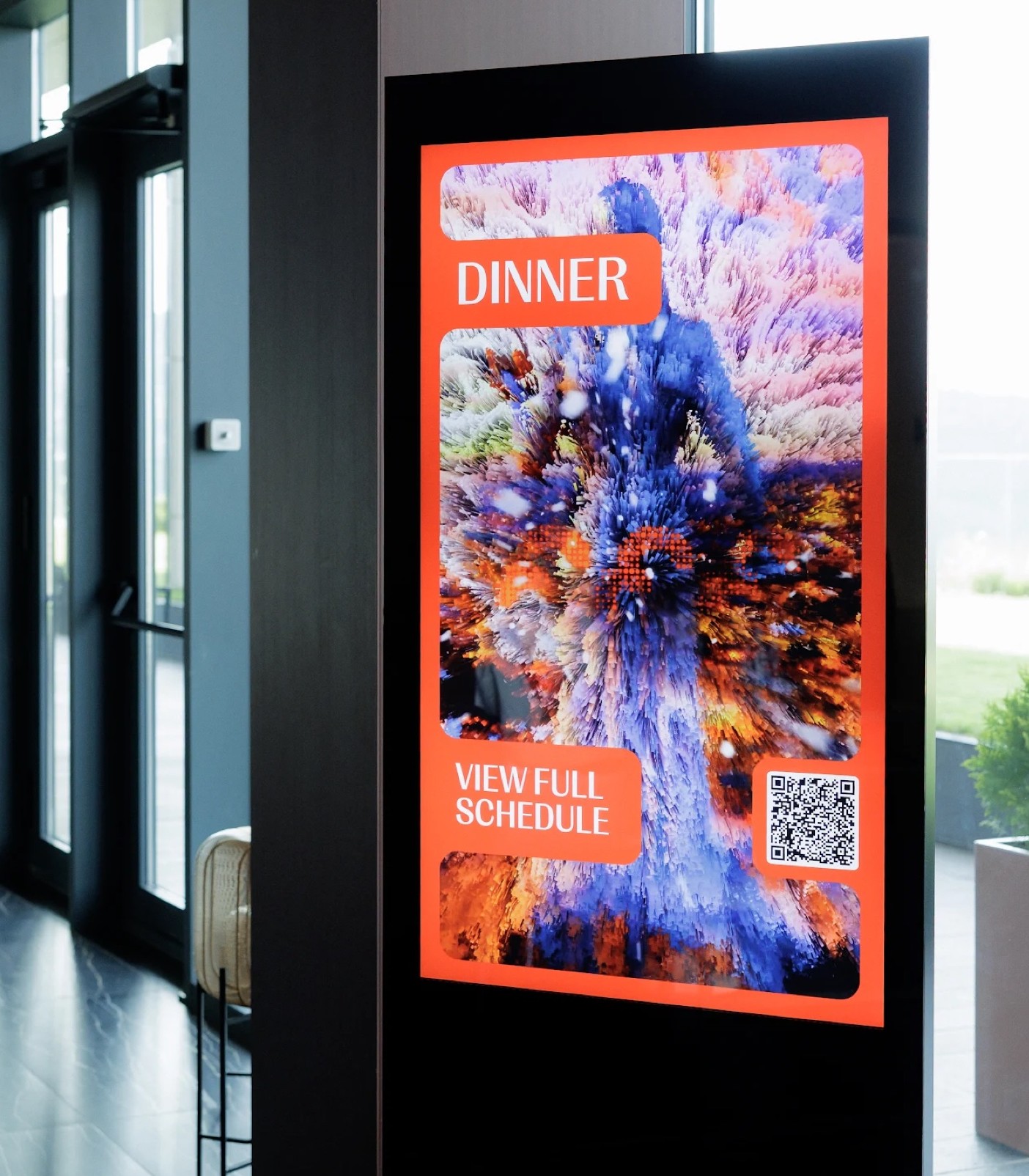 Digital-signage display in a lobby running the event's footage preset