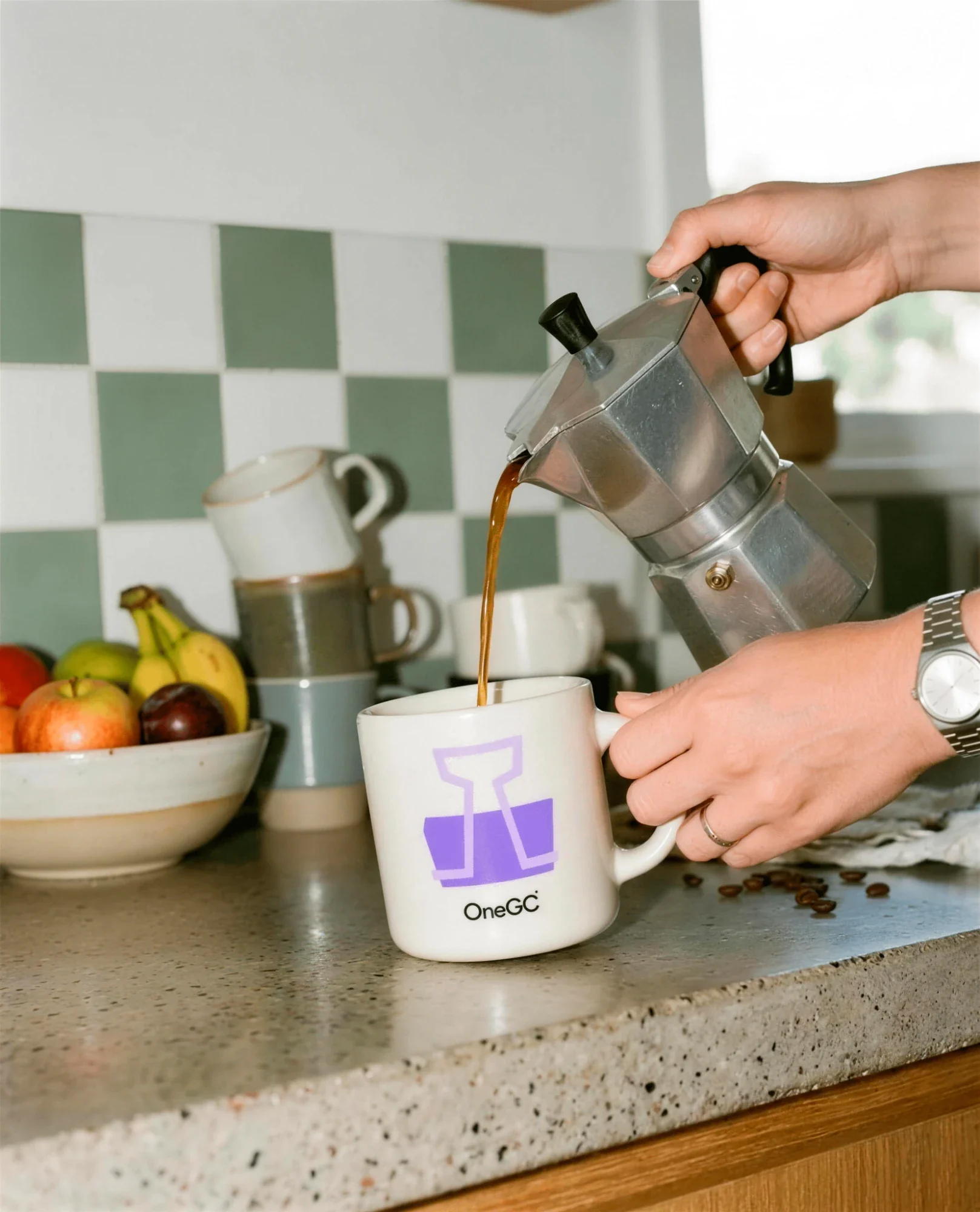Coffee poured into a white OneGC mug with the purple binder-clip icon
